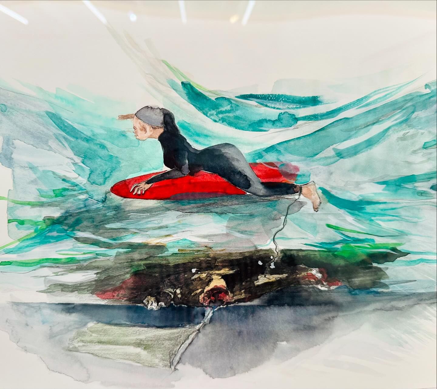 Watercolor painting of a woman in a wetsuit lying on a red surfboard in teal-colored water, artwork inside a white frame, illustration.