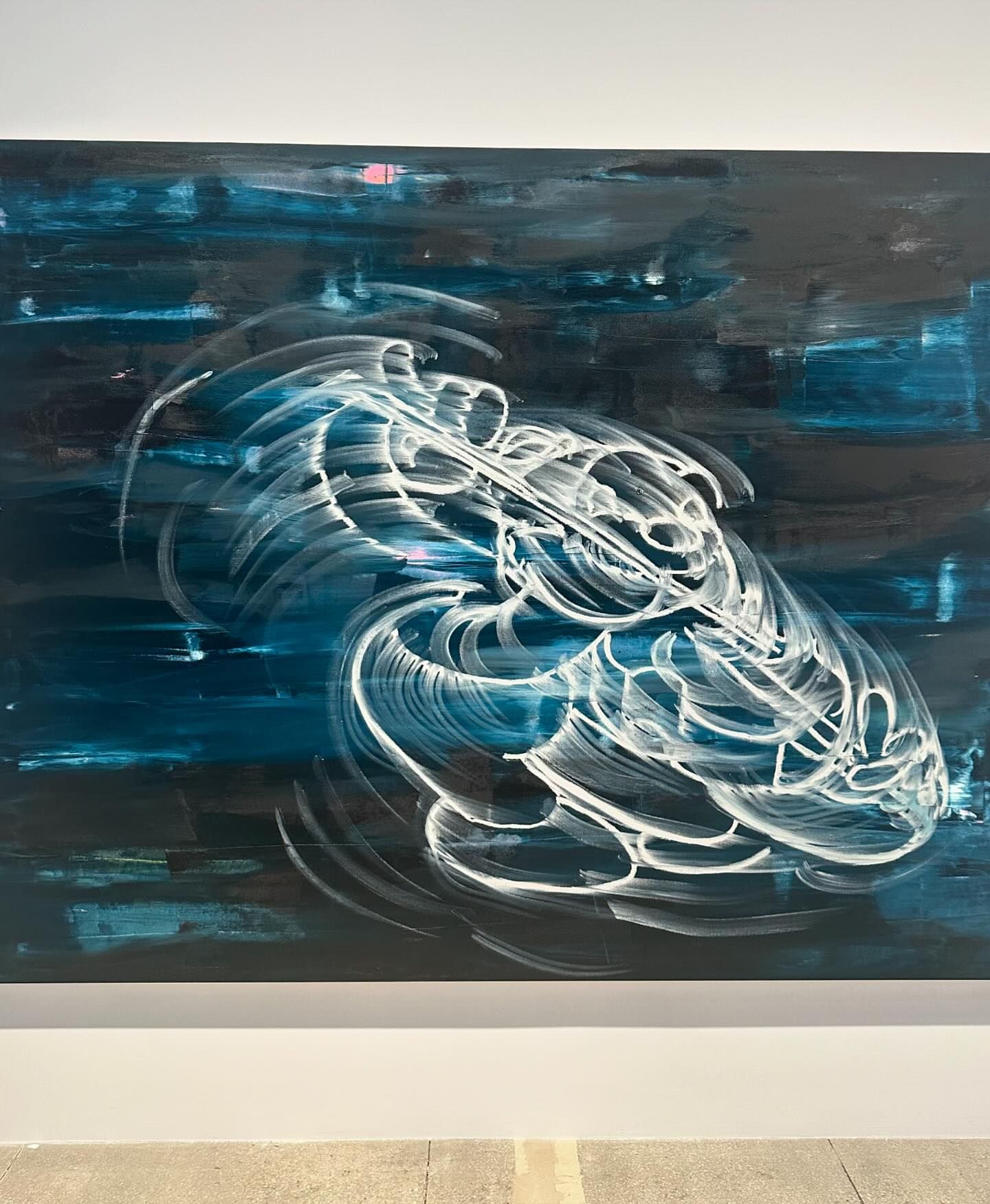 Abstract painting with white brushstrokes resembling a swirling vortex against a contrasting teal and dark background on white wall.