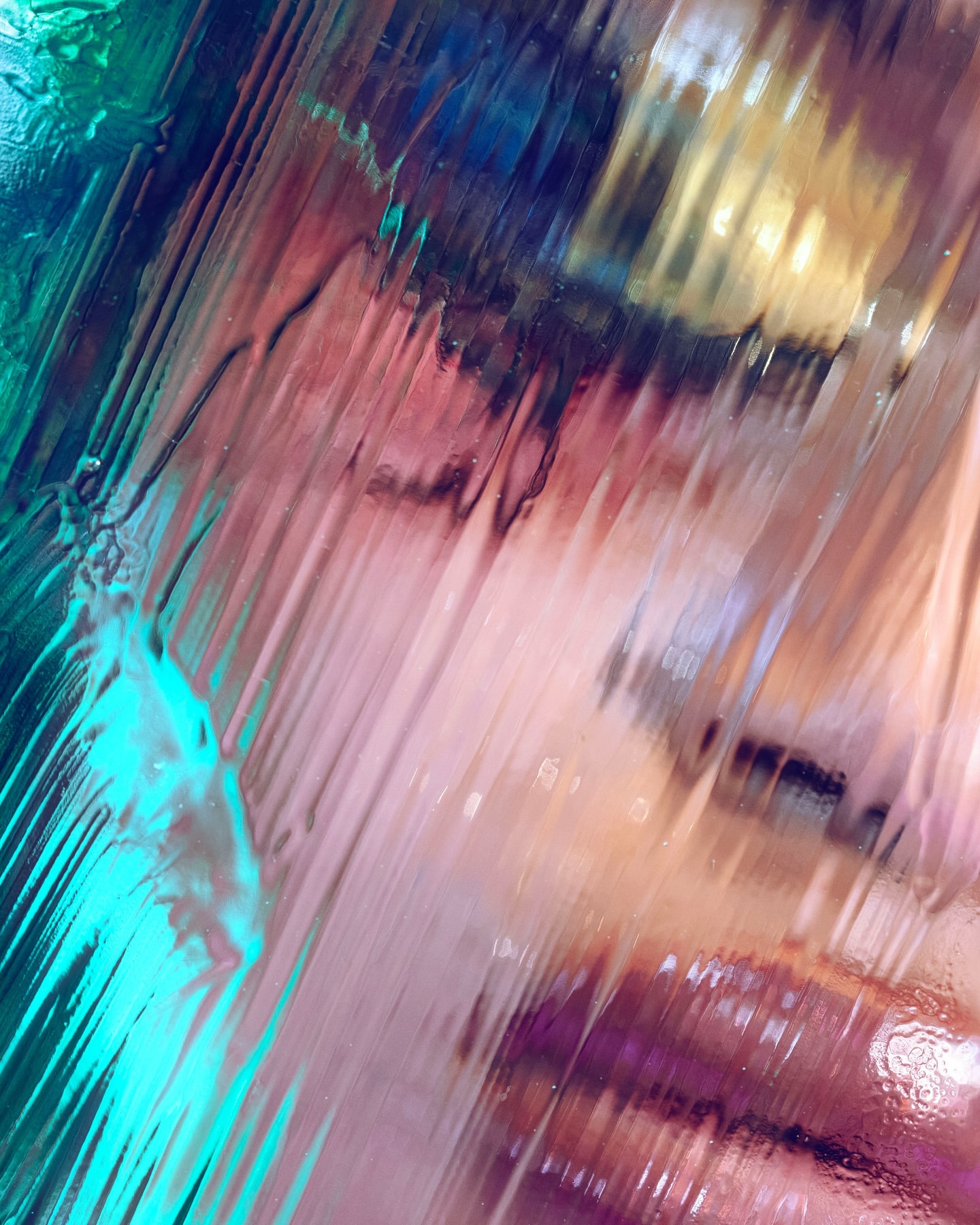 Abstract image of light shining through textured glass, showing patterns in hues of blue, purple, pink, and yellow for creative use.