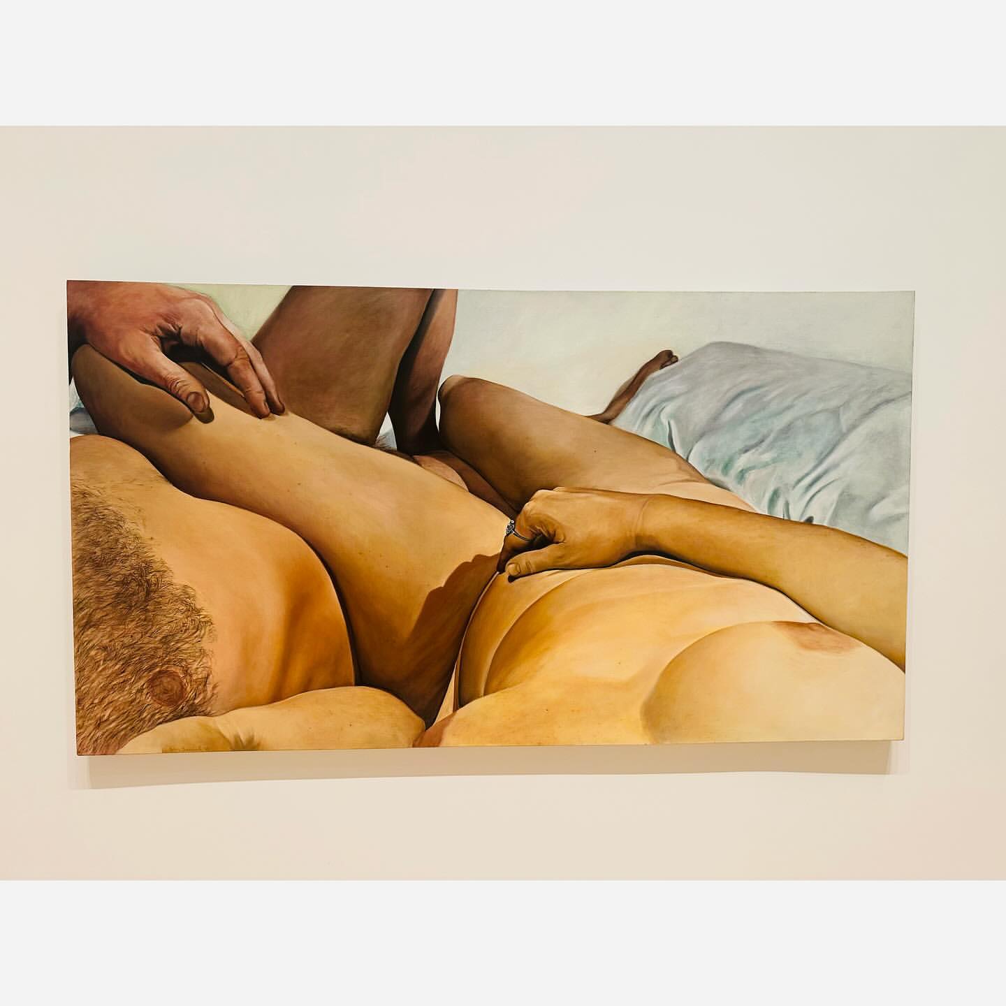 Oil painting of three nude individuals lying on a bed, featuring warm tones and visible brushstrokes, capturing an intimate setting.