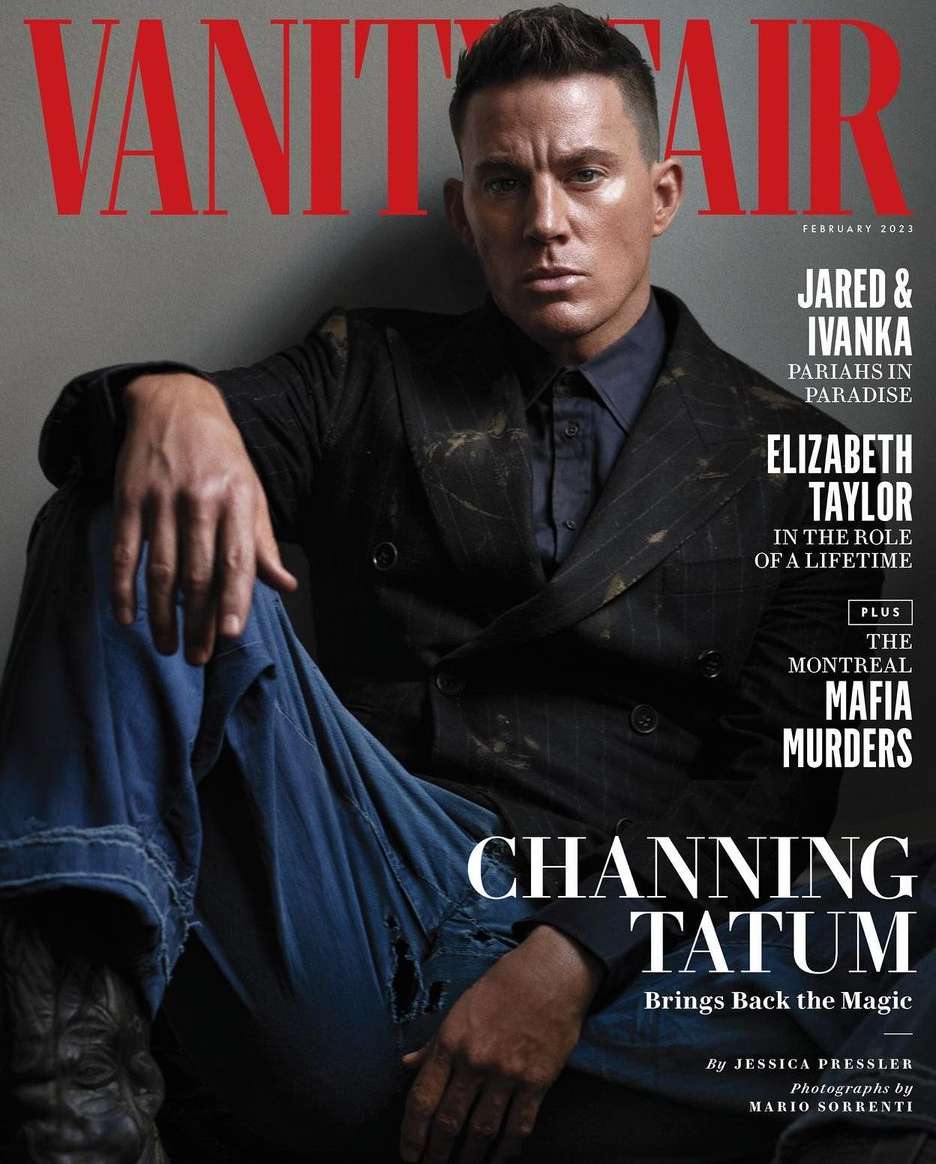 Channing Tatum in a magazine cover image. He is wearing a dark jacket with blue jeans, seated against a gray wall background.