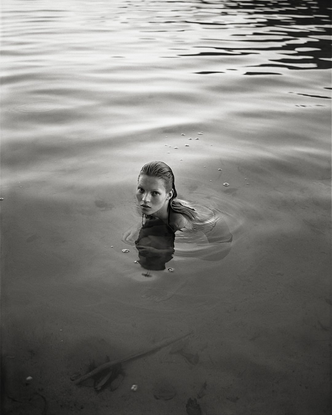 Kate Moss submerged in lake water with wet hair looking at camera by Mario Sorrenti