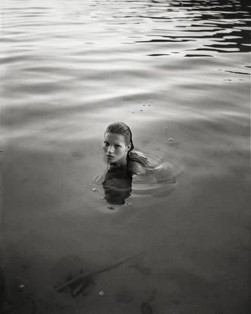 Kate Moss submerged in lake water with wet hair looking at camera by Mario Sorrenti