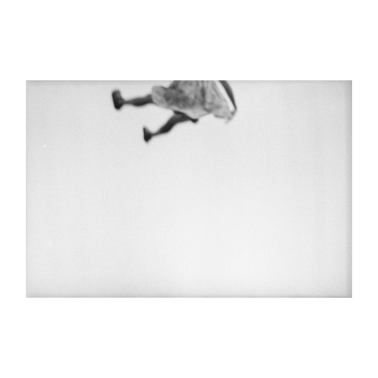 Monochrome image of a blurry human figure with a dress against a light background, creating an abstract and ethereal aesthetic.