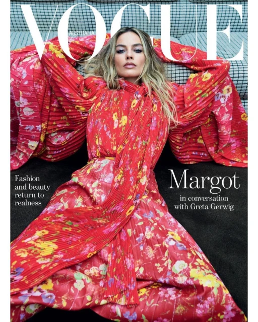 Vogue Australia cover featuring model Margot Robbie in a red floral dress lying on a grey textured surface with bright studio lighting.