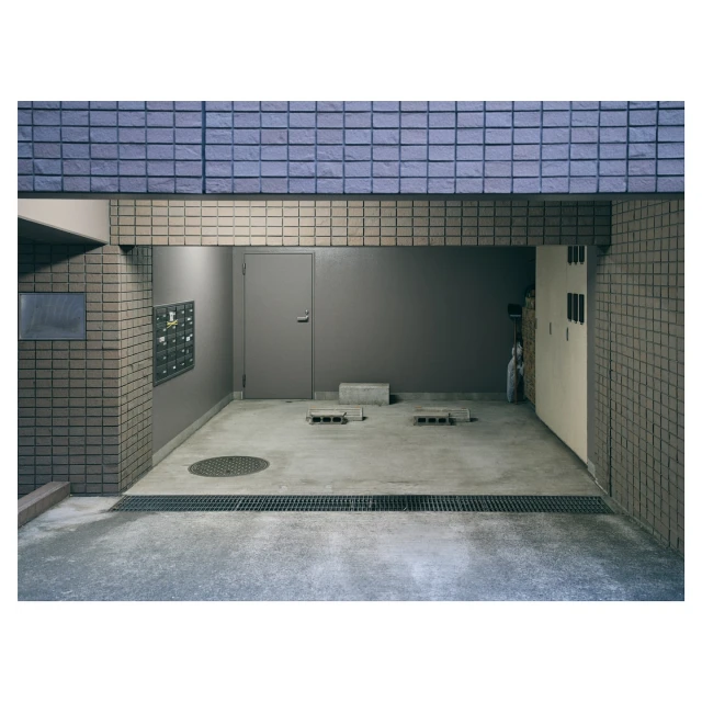 An empty parking garage with a closed metal door and blue brickwork, showcasing a quiet, industrial urban architecture scene.