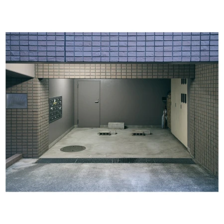 An empty parking garage with a closed metal door and blue brickwork, showcasing a quiet, industrial urban architecture scene.