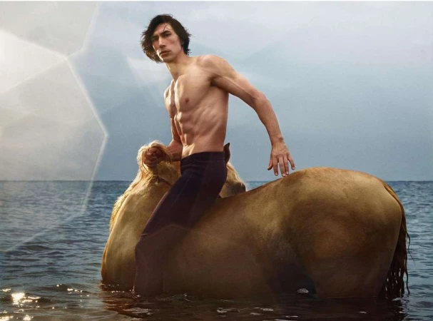 Adam Driver riding a horse in the ocean. The shirtless celebrity poses for the camera with water and sky behind the scene. 