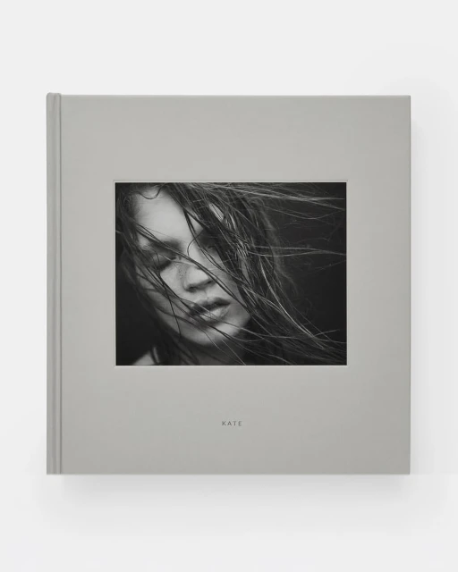 Book cover featuring a black and white portrait of Kate Moss with windswept hair, minimalist design, and soft gray tones.