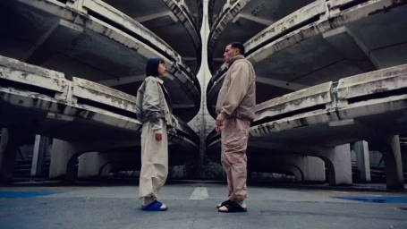 Two people facing each other in a concrete multi-level parking structure photographed by Mario Stumpf in Frankfurt.