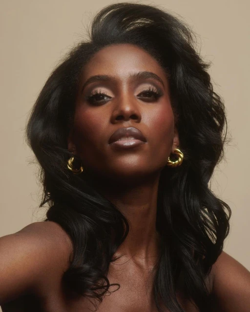 Headshot of Black woman with styled dark hair and golden hoop earrings, gazing upward in a beauty or fashion style portrait.