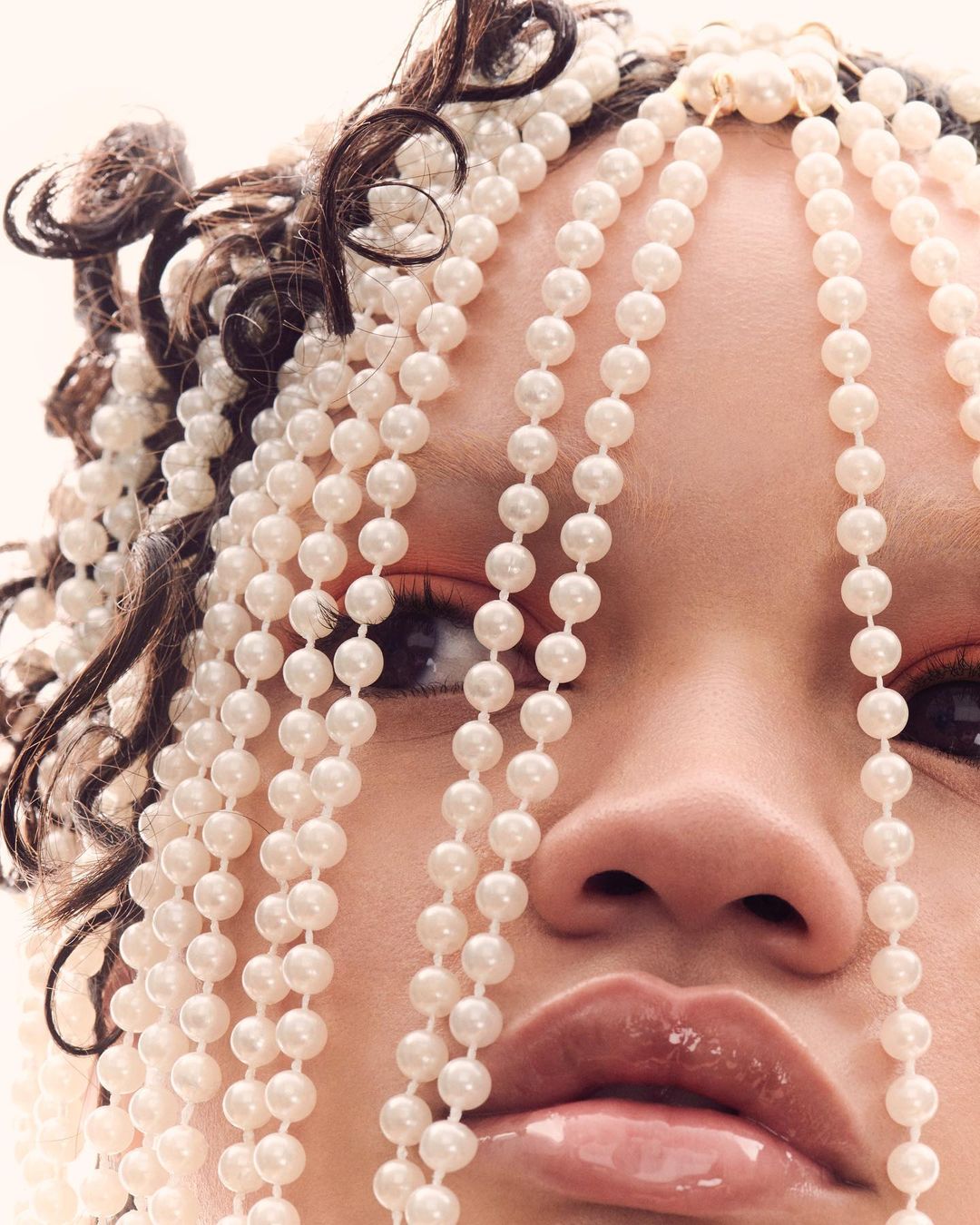 Portrait of a person with pearls adorning their hair and face, creating a glamorous and eye-catching beauty aesthetic.