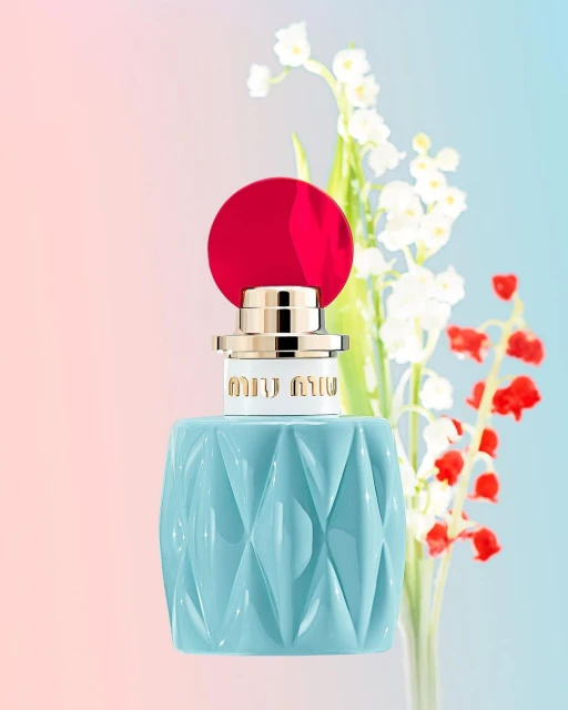 Miu Miu perfume bottle close-up on a gradient background with lily of the valley and red flowers, product shot for beauty and fashion.
