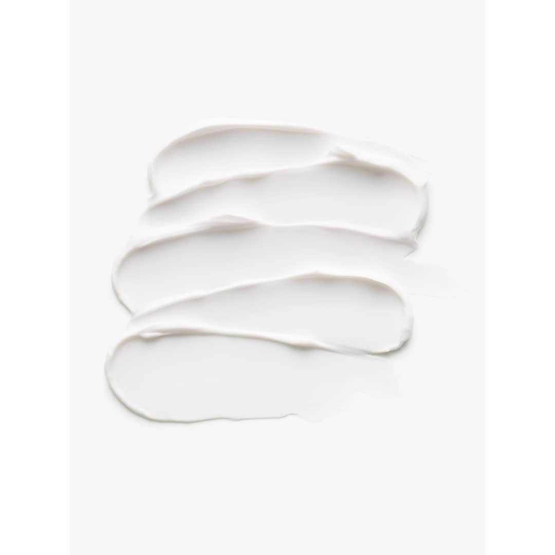 Close-up of white cream swatches creating textured strokes on a white backdrop, ideal for beauty or skincare product marketing.