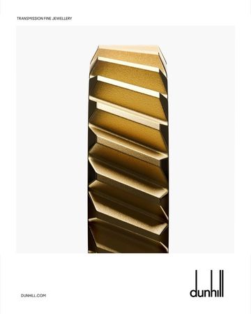 Angled gold band ring on a white background. Jewelry advertisement for Dunhill. Studio shot. Gold geometric ring.