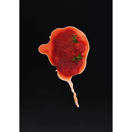 Overhead shot of strawberry puree with green sprigs on a black surface, offering a vibrant contrast of red and green.