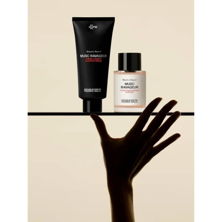 Frederic Malle Musc Ravageur product shot. Black shower cream tube and perfume bottle on shelf. Silhouette of reaching hand.
