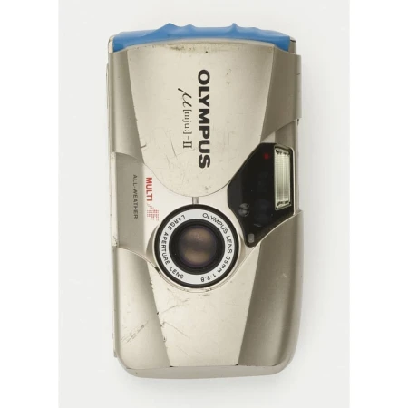Silver Olympus [mju:]-II camera with a 35mm lens. Features include multi all-weather, large aperture. The camera sits on a white backdrop.