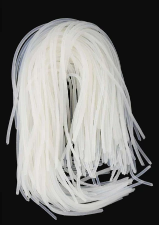 A pile of translucent, glutinous rice noodles on a black surface, showing the texture and shape of the noodles in detail.