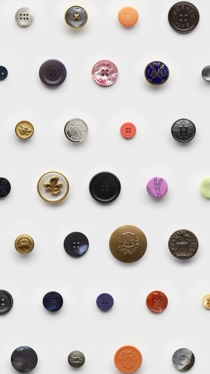 Collection of assorted buttons in varying sizes, colors, and designs arranged in a grid pattern on a clean white background.
