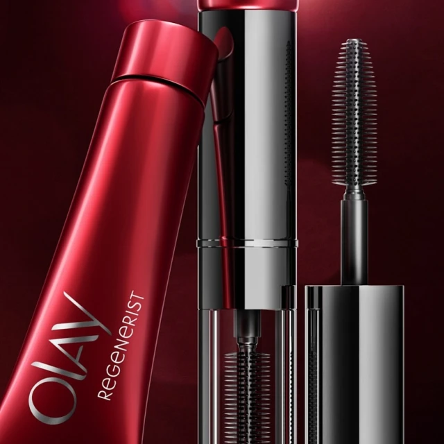Close-up of OLAY Regenerist product showing a red tube and a black and silver mascara wand with spiral brush for beauty advertising.