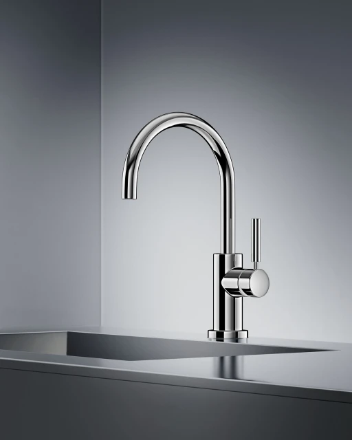 Close-up studio shot of a modern chrome faucet mounted on a countertop, set against a gradient grey backdrop.