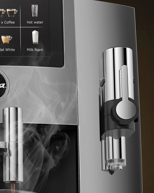 Close-up of a modern, chrome-plated coffee machine with a digital display and steam rising, highlighting its sleek design and functionality.