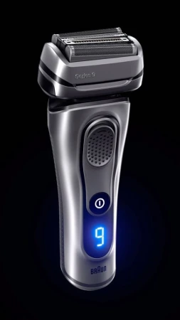 Close-up studio shot of a silver and black Braun Series 9 electric shaver on a black background with blue illumination and digital display.