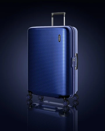 Studio shot of a dark blue Samsonite suitcase with a textured surface and a telescoping handle extended, set against a dark blue gradient.