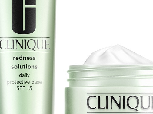Clinique skincare products: a bottle of Redness Solutions Daily Protective Base SPF 15 and a jar of moisturizer on a white background.
