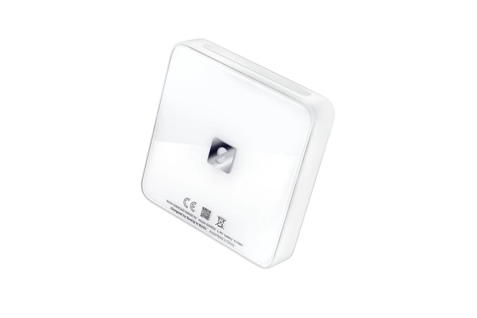 Close-up studio shot of a white, square-shaped device with rounded edges, featuring a reflective logo at its center, against a white background.