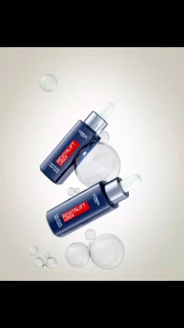 Two L'Oreal Revitalift Laser serums are angled against a gradient background with transparent spheres, showcasing beauty and skincare.
