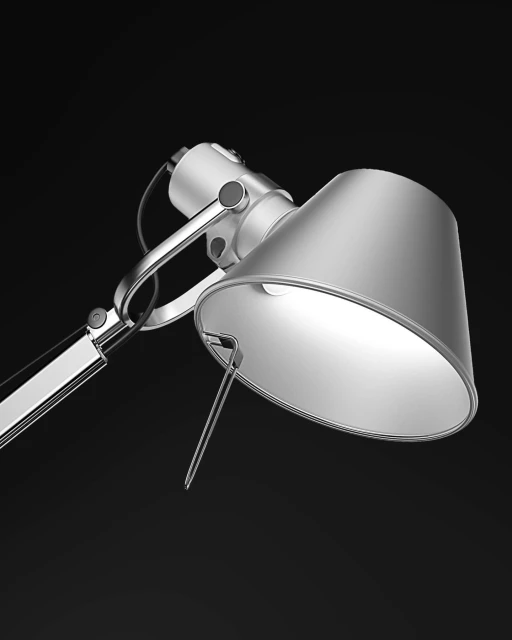 Silver adjustable table lamp illuminates a dark interior, highlighting modern design with metal finish and bright light.