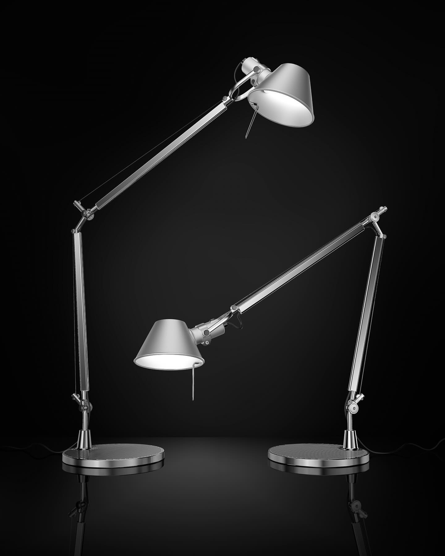 Two silver adjustable desk lamps with conical shades illuminate against a dark background, showcasing modern design and functionality.