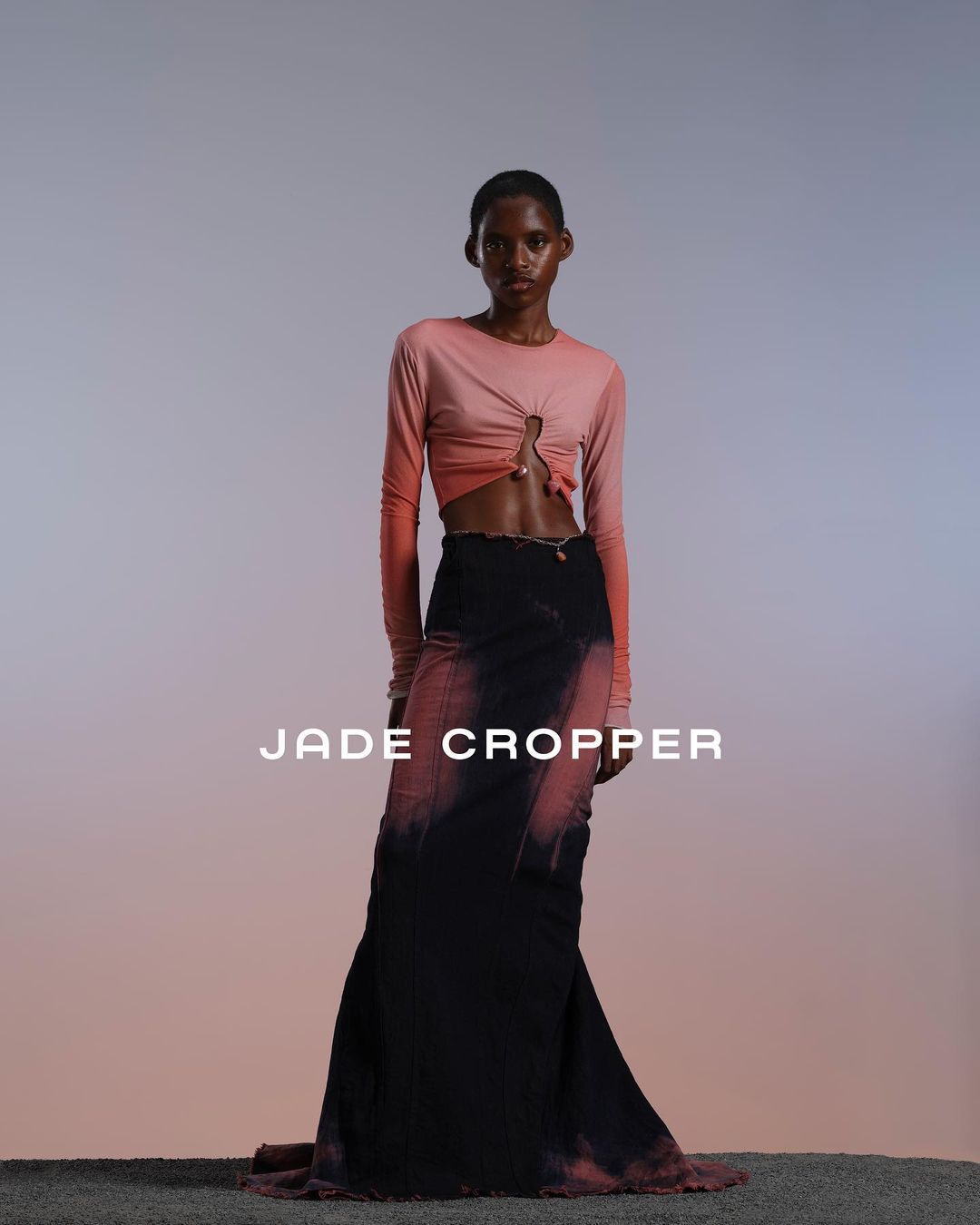 Model wearing a pink ombre long-sleeve top and black floor-length skirt in a studio setting by Mariya Pepelanova
