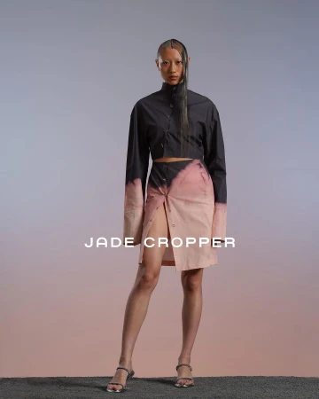 Model wearing a black crop top and pink dip-dyed skirt standing against a gradient studio backdrop in Paris