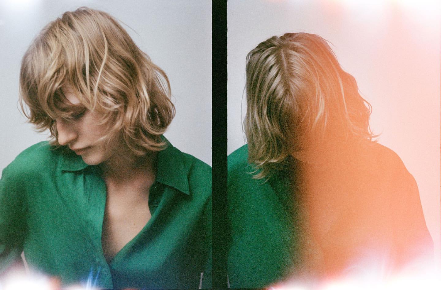 Studio diptych of a blonde adult woman in a green button-down shirt looking down against a gradient neutral backdrop with pink light flare.