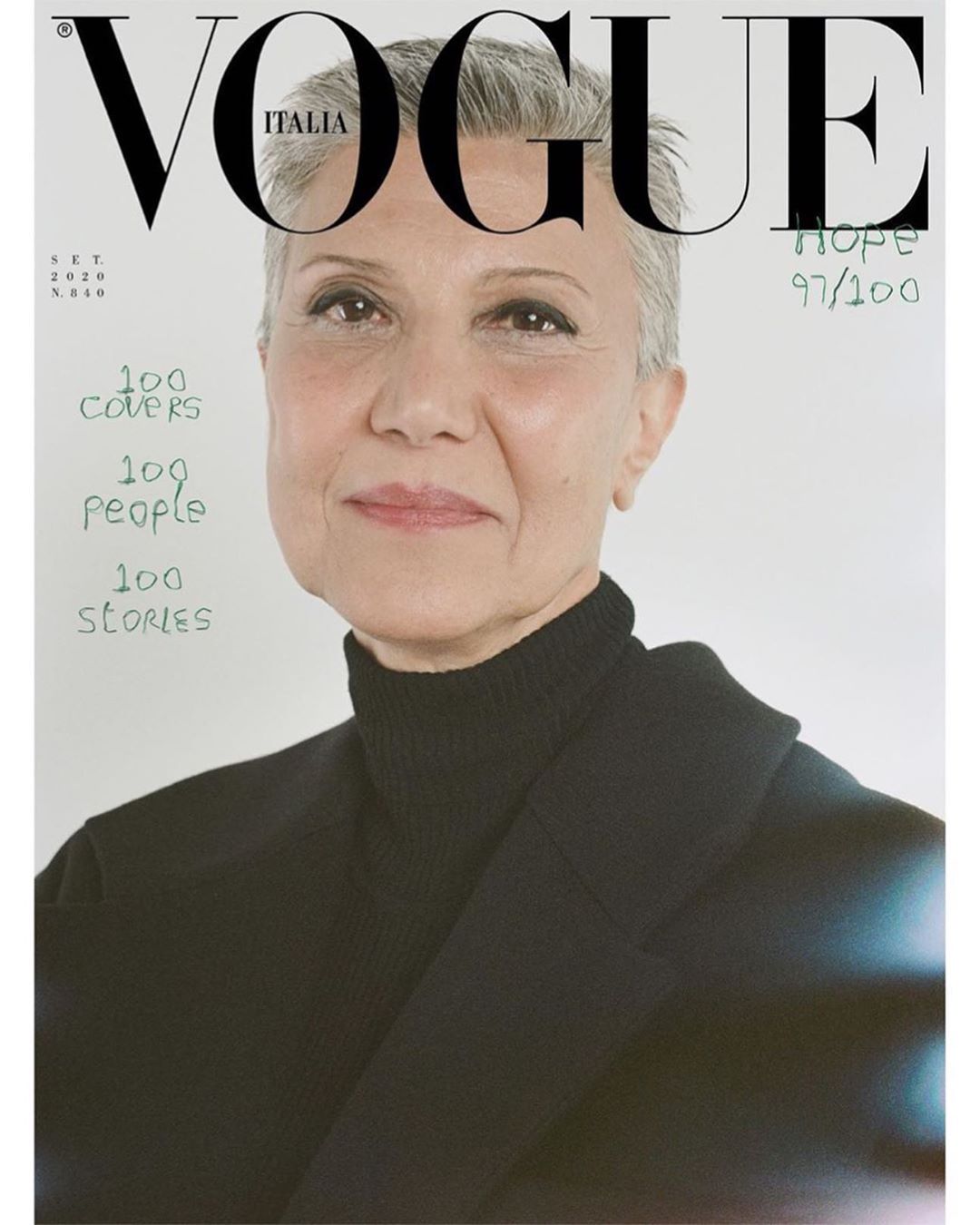 Vogue Italia cover featuring a close-up portrait of an adult female with short gray hair wearing a black turtleneck and blazer against a white background.