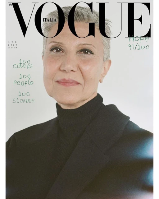 Vogue Italia cover featuring a close-up portrait of an adult female with short gray hair wearing a black turtleneck and blazer against a white background.