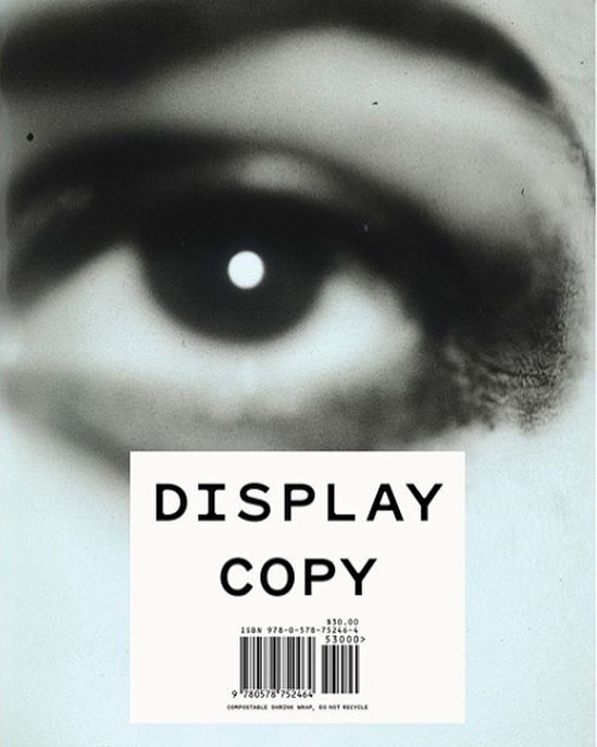 Close-up of an eye in black and white, contrasted against a label with the words 'DISPLAY COPY' printed in bold letters.