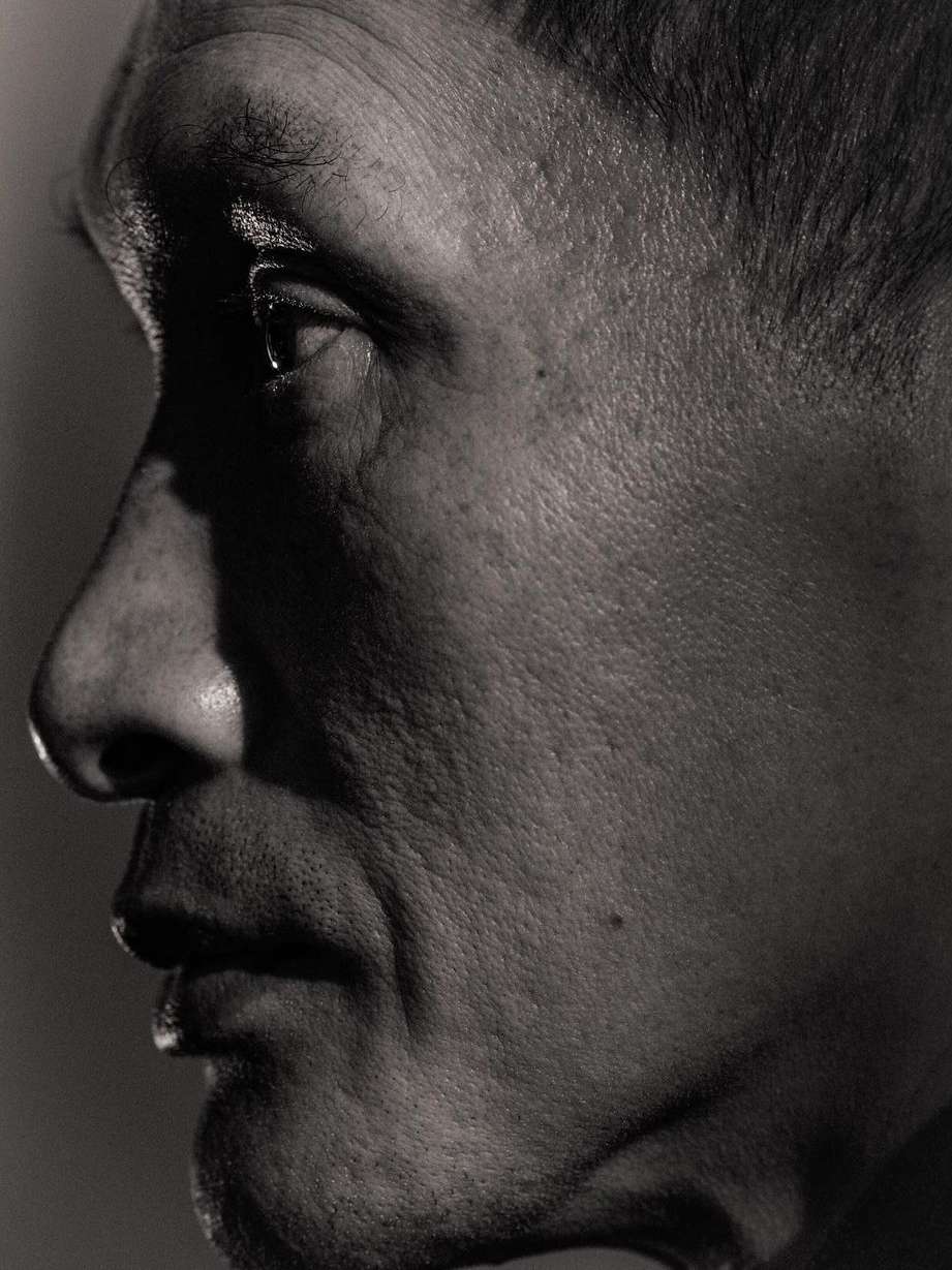 Monochrome portrait of a mature adult male's face in profile, featuring the interplay of light and shadow, and close-up camera work.