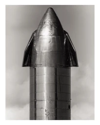 Monochrome close-up of a large stainless steel spacecraft nose cone against an overcast sky by Mark Mahaney