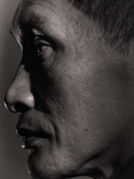 Close-up profile portrait of a man in dramatic low-key lighting by Mark Mahaney