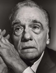 Close-up black and white portrait of an elderly man with folded hands near his face by Mark Mahaney