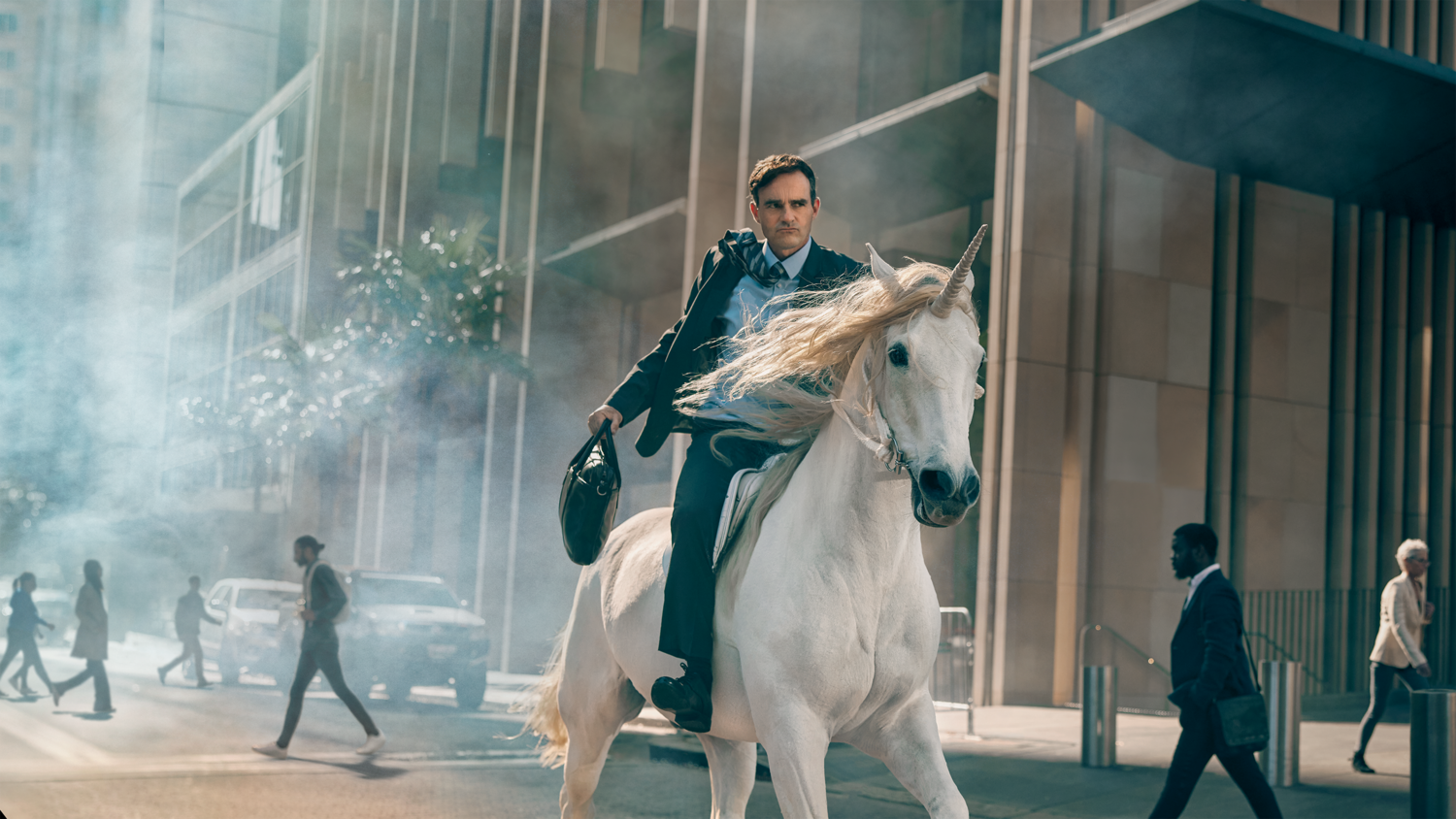 Man in suit riding a white unicorn on a city street with pedestrians and tall buildings, holding briefcase, mystical and business themes.