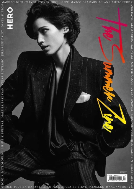 Magazine cover featuring a young adult with short hair in a striped suit, styled in editorial black and white with text overlay.