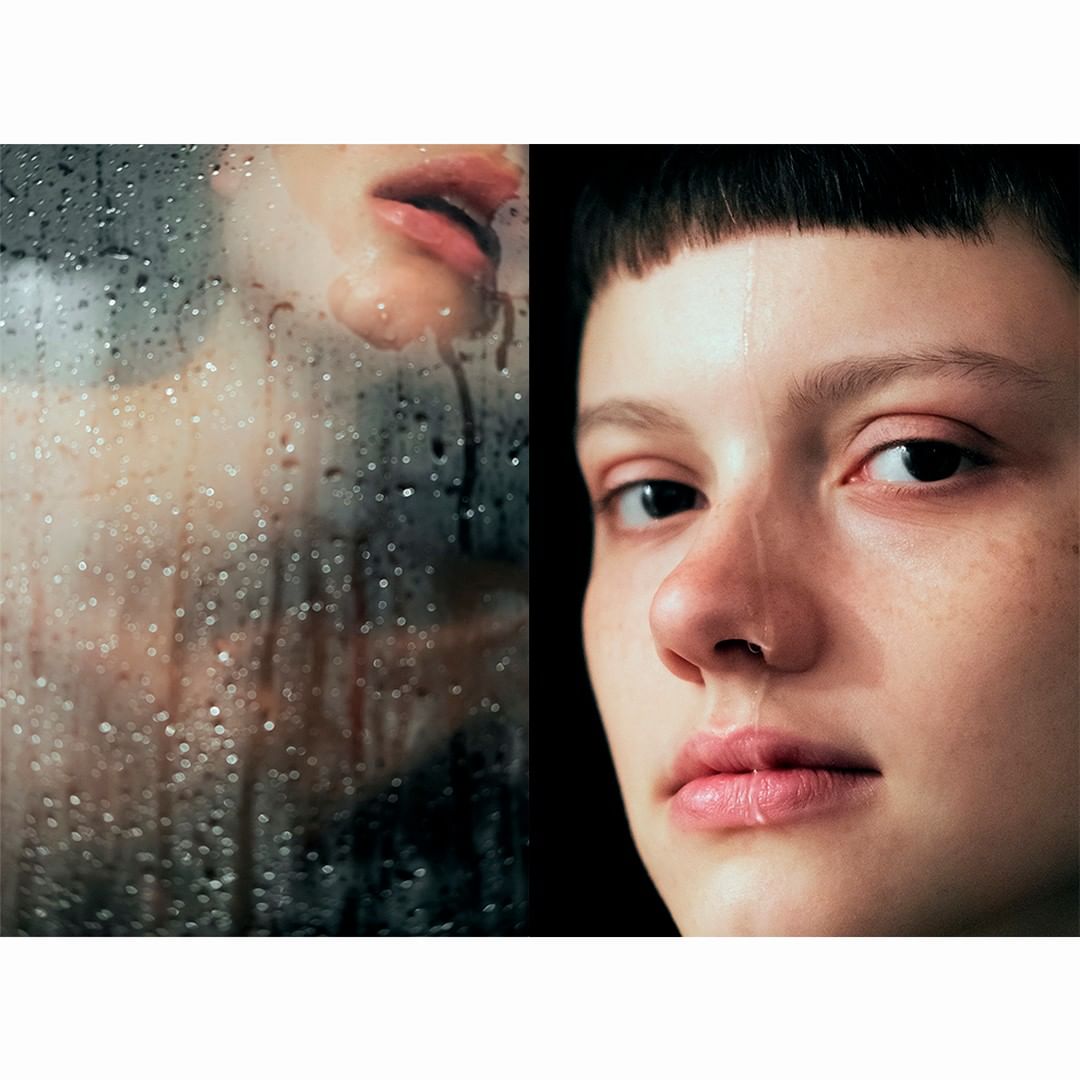 Close-up of a young woman with short dark hair and tear-stained face, alongside a steamed-up glass covered in water droplets.