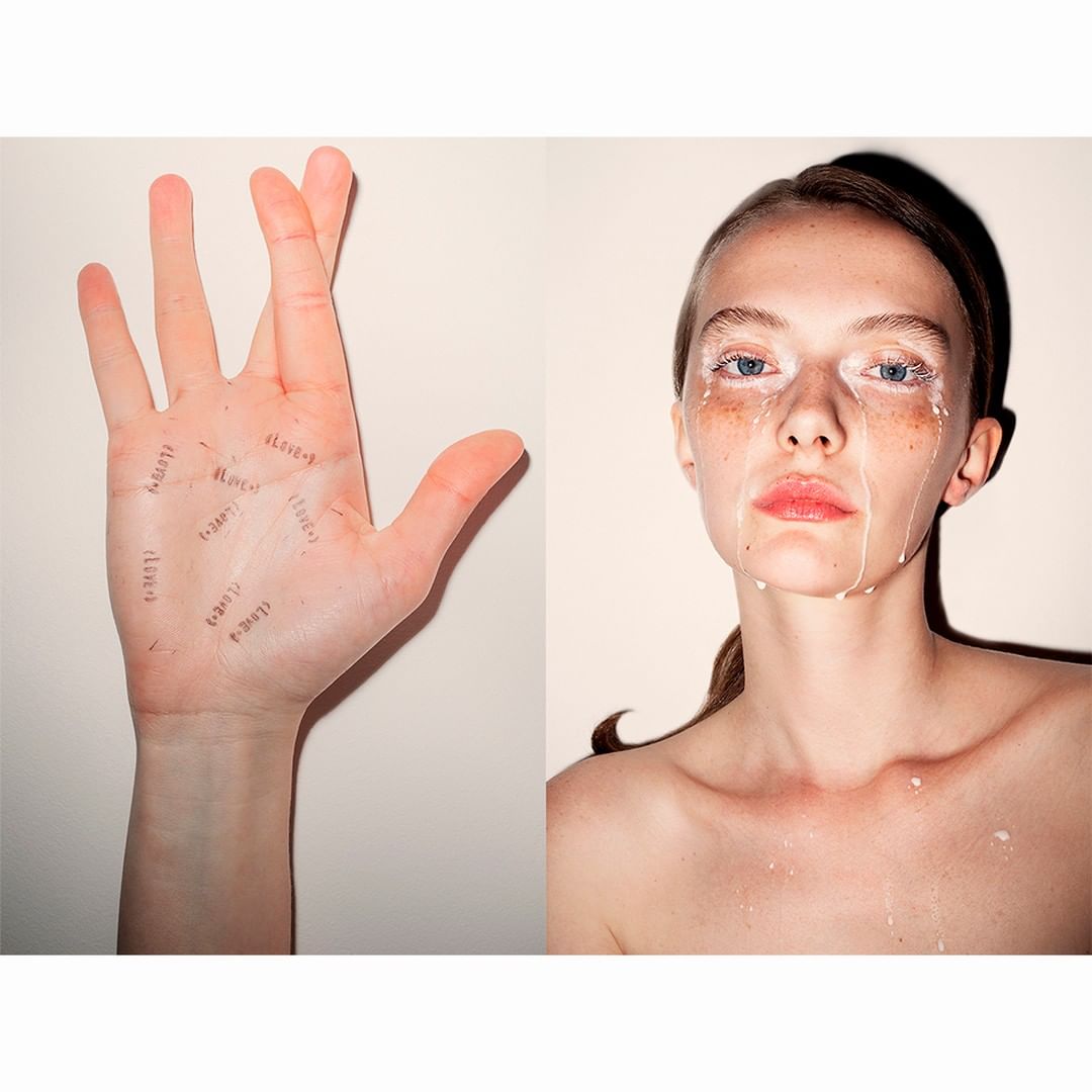 Artistic studio shot with a woman's face partially covered in white paint, contrasted with a hand inscribed with handwritten words.