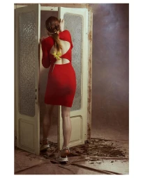 Woman in red dress opening vintage double doors with textured glass panels