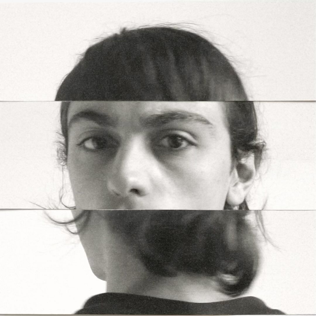 Abstract portrait of a person's face fragmented into horizontal bands on a white background, creating a surreal, distorted aesthetic.
